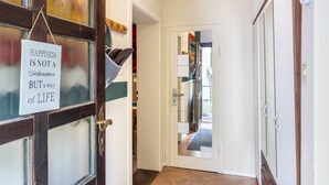A hallway with a door leading to a room, a sign on the door, and a mirror reflecting the room. - "Fuchsrevier" Apartment for Installers and Vacationers (Erkerode)