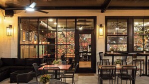 An indoor dining area with tables and chairs, a sofa, and a ceiling fan. - City Grammar (Mcminnville)