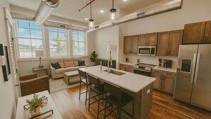 A modern kitchen with stainless steel appliances, a central island, and wooden cabinets. - City Grammar (Mcminnville)