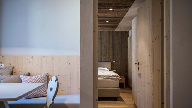 Un pasillo estrecho con paredes de madera y una cama al final.