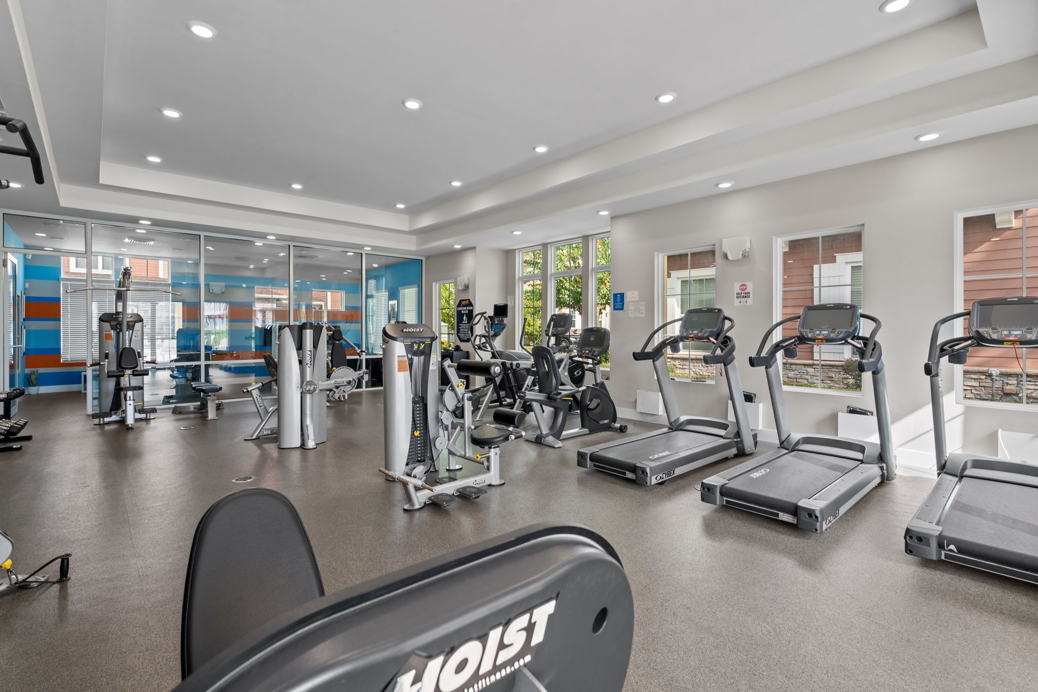 Uma academia moderna com diversos equipamentos de exercício, incluindo esteiras e máquinas de peso.