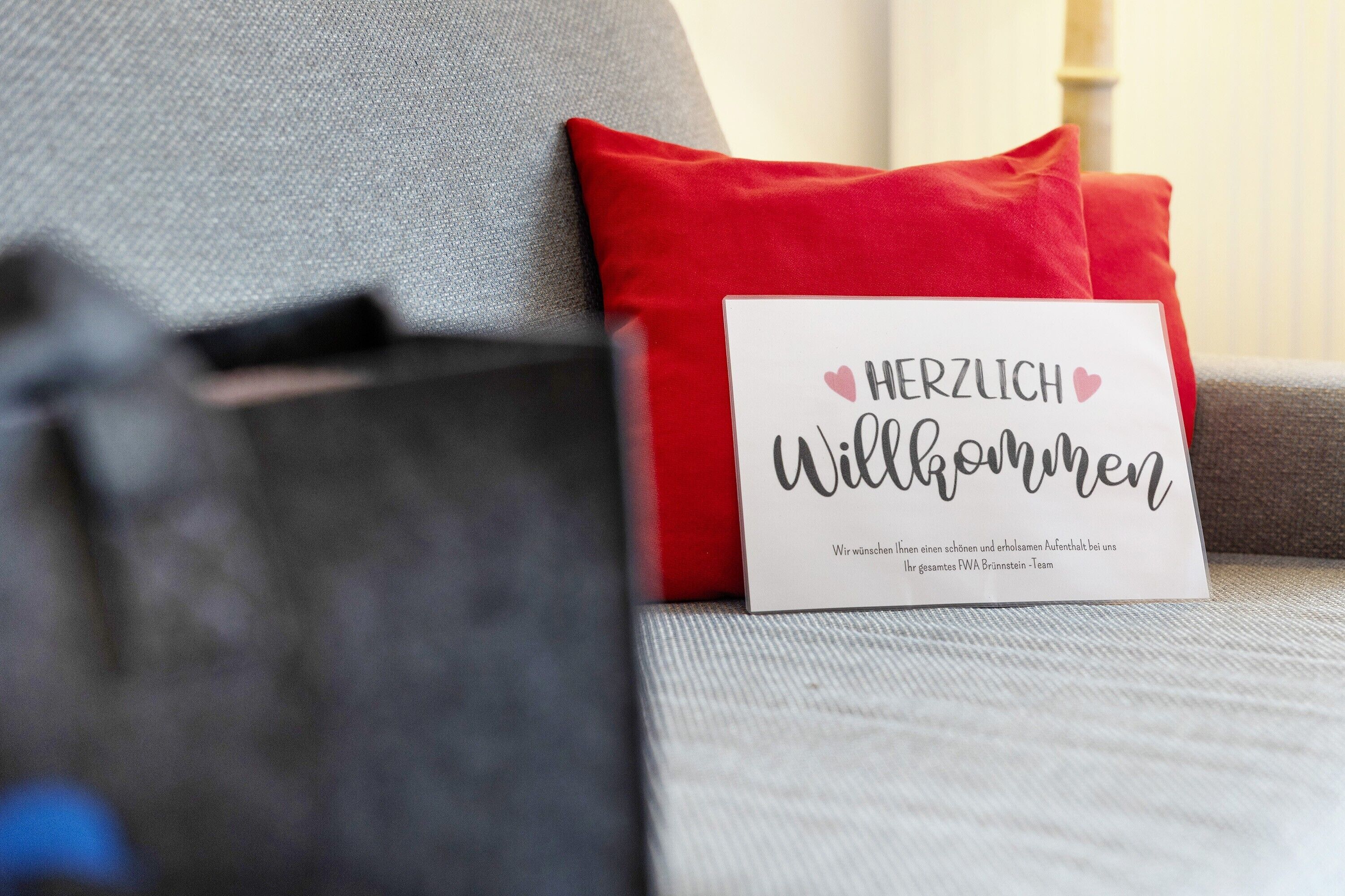 A cushion with a greeting card on a sofa.
