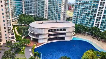 Un edificio circular con una piscina en el centro, rodeado de edificios residenciales altos.