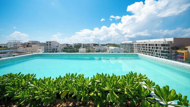 A rooftop swimming pool with a clear blue sky and clouds. - Comfortable studio with pool and gym - Huaya 101 (Playa del Carmen)