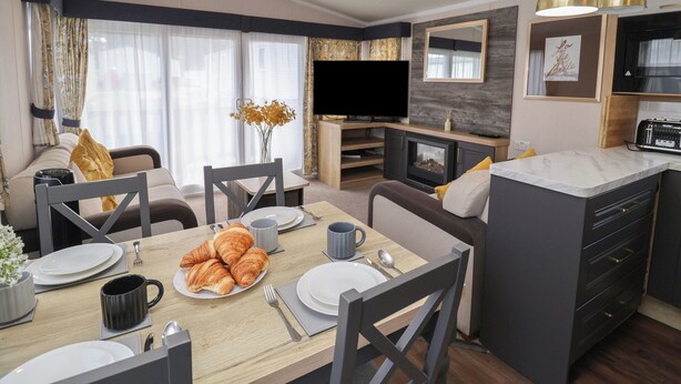 Ein modernes Wohnzimmer mit einer Couch, einem Esstisch und einer Küchenzeile.
