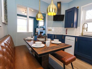 Eine moderne Küche mit blauen Schränken, einer Holzinsel und einer Bank.