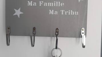 Un atril de pared para llaves con una placa que dice 'Mon Bonheur Ma Famille Ma Tribu' y estrellas decorativas.