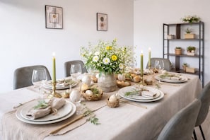 A dining table set with plates, glasses, candles, and a centerpiece of flowers. - Family getaway in Colmar with balcony (Colmar)