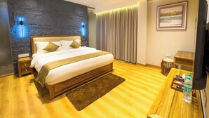 A modern hotel room with a large bed, wooden ceiling, stone wall, and a flat-screen TV. - the perch shimla (Shimla)