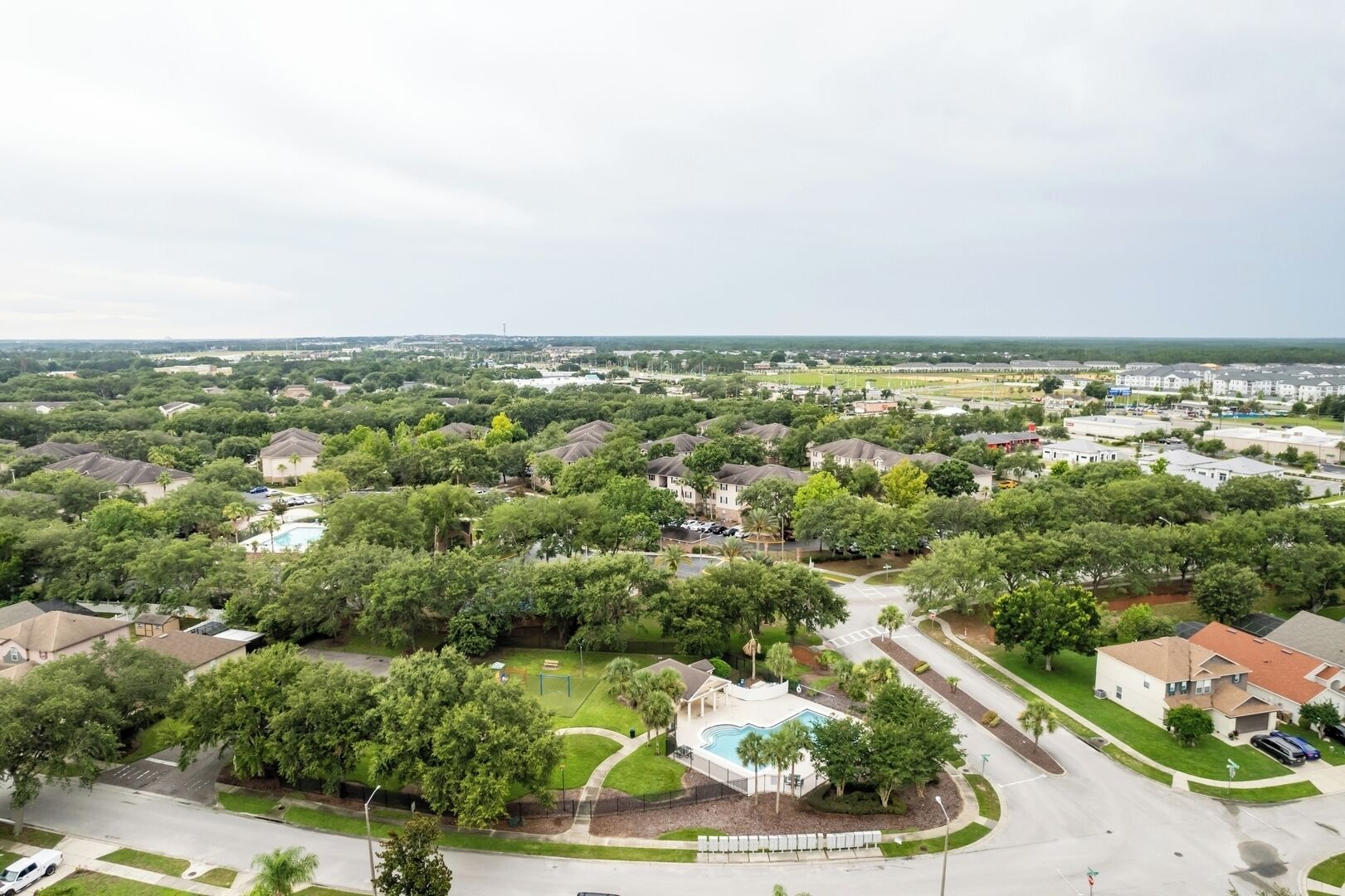 A residential area with houses, a swimming pool, and a road.
