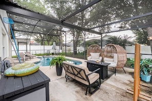 A covered outdoor area with a pool, seating, and potted plants. - Private King BR + Pool Access Near Disney (Clermont)
