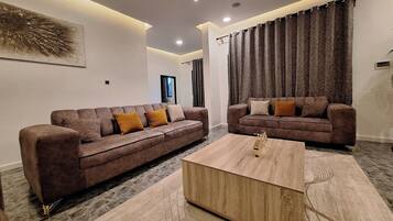 Deluxe-Apartment, Balkon, Stadtblick | Wohnbereich | Flachbildfernseher