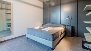 Une chambre moderne avec un grand lit, des lampes de chevet et une vue sur un balcon.