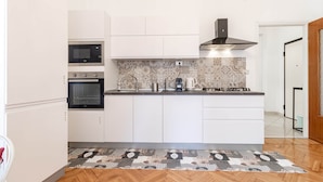 A modern kitchen with white cabinetry, a patterned backsplash, and a herringbone floor pattern. - Route 66 - Sea and Beaches (Sanremo)