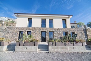 A modern two-story building with a stone facade and multiple windows. - AGAVE VICTORIAE REGINAE APARTMENT - Vista mare (Sanremo)