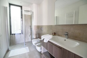 A modern bathroom with a glass shower enclosure, a toilet, and a large sink with a mirror above. - AGAVE VICTORIAE REGINAE APARTMENT - Vista mare (Sanremo)