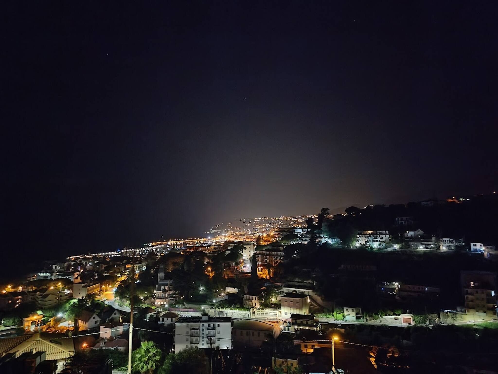 Un paisaje urbano nocturno con edificios e iluminadas calles.