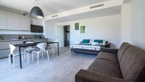 A modern living space with a kitchen, dining area, and a bedroom.