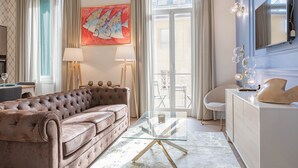 Un salon moderne avec un canapé capitonné, une table basse en verre et une console blanche.