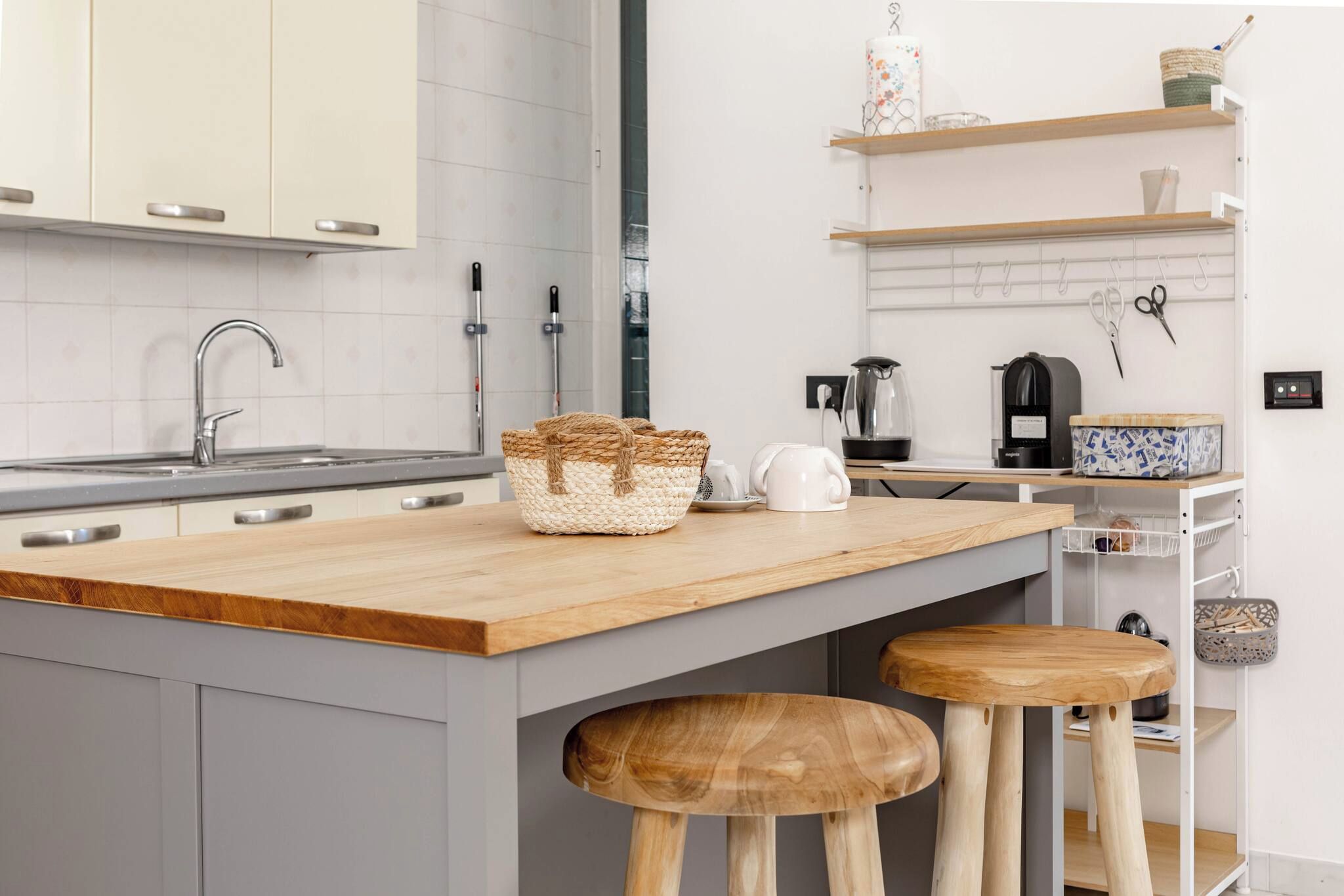 A modern kitchen with a wooden countertop, a built-in sink, and a coffee machine.