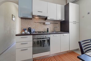 Réfrigérateur, un four, surface de cuisson, vaisselle et ustensiles