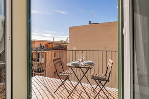 A balcony with a table and chairs, a view of buildings, and a clear sky. - CASAPA - Parcheggio - Sanremo (Sanremo)