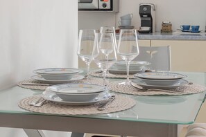 A dining table set with plates, glasses, and cutlery on a glass table with placemats. - CASAPA - Parcheggio - Sanremo (Sanremo)