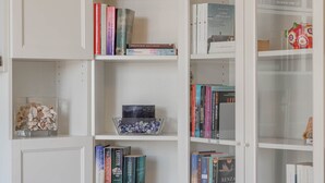 A bookshelf with various books and decorative items. - Casapa - Parking - Sanremo (Sanremo)