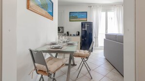 A dining area with a glass table, chairs, and a view of the kitchen and living room. - Casapa - Parking - Sanremo (Sanremo)