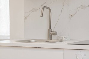 A modern kitchen with a stainless steel faucet, a built-in oven, and a white countertop. - LIBERTY IN RIVIERA - Sanremo (Sanremo)