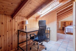 A wooden interior with a desk, chair, lamp, and a view of a bedroom. - OASI SERENA - Parcheggio-Giardino (Liguria)