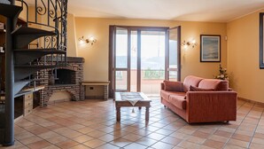 Ein Wohnzimmer mit Kamin, einer Couch und einer Treppe.