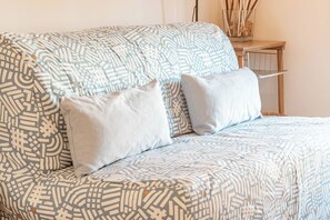 A bed with a patterned bedspread and two pillows.