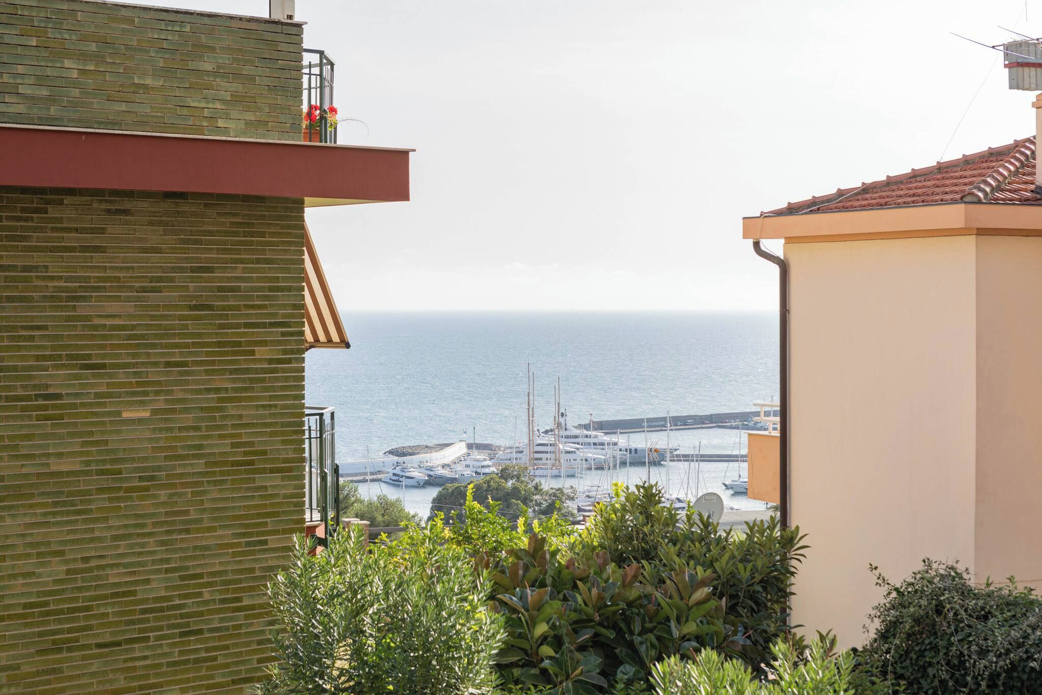 Une vue sur la mer depuis un balcon, avec des bateaux et un pont visibles au loin.