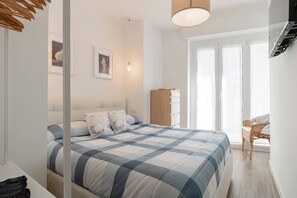 A bedroom with a bed, a nightstand, a dresser, and a chair. - SUITE LA MER - Sanremo - Spiagge (Sanremo)