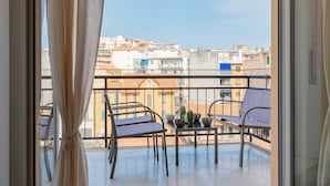 Ein Balkon mit zwei Stühlen, einem Tisch und einem Blumentopf.
