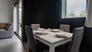 A dining area with a table set for four, chairs, and a sofa. - TAGGIASCA (Taggia)