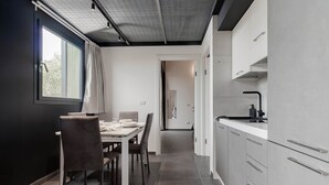 A modern kitchen with grey cabinets, a white countertop, and a black faucet. - TAGGIASCA (Taggia)