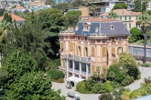 A historic building with a central courtyard, surrounded by lush greenery.