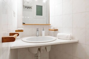 A modern bathroom with a white sink, a mirror, and wooden towel racks. - CASA GIULIETTA - Sanremo (Sanremo)