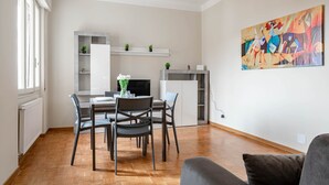 Ein modernes Wohnzimmer mit Essbereich, Kamin und einem großen abstrakten Gemälde an der Wand.