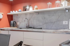 A kitchen with a marble backsplash, a stainless steel sink, and a coffee maker. - CENTRAL CHARM - Sanremo - Ariston (Sanremo)