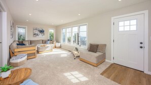 A spacious living room with a sofa set, a coffee table, and a small table with a plant. - The Coastal Retreat, Scenic Harbor, Ocean Views, Walk to Beach, Restaurants (El Granada)