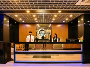 A reception desk with a sign reading 'Hotel Park Valley' and a modern ceiling design. - Hotel Park Valley International (Dhaka)