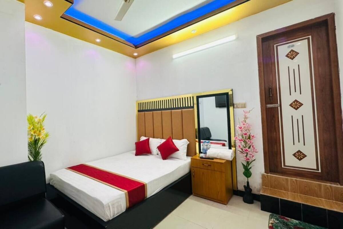 Una habitación de hotel con cama, mesita de noche y espejo.