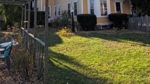 A two-story house with a front porch, a wooden fence, and a garden area. - 1880 updated Victorian 1st floor, water views (Salem)