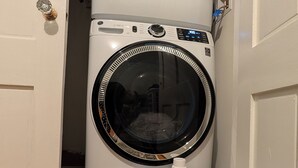 A compact washer and dryer unit in a small laundry room with patterned floor tiles. - 1880 updated Victorian 1st floor, water views (Salem)