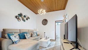 A modern living room with a sofa, coffee table, TV, and decorative wall art. - Villa Magn lia by Atlantic Holiday (Machico)