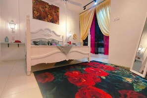 Une chambre à coucher avec un lit, une table de chevet, une lampe fixée au mur et un grand miroir.
