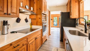 Une cuisine avec des armoires en bois, des appareils électroménagers en acier inoxydable et une grande fenêtre.